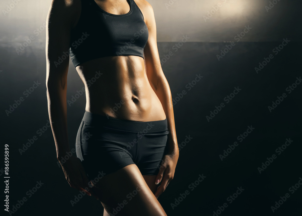 Naklejka premium Fit body of beautiful, healthy and sporty girl. Slim woman posing in sportswear.