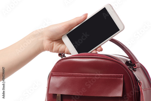 A hand put the phone in the female handbag