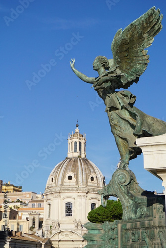 Angel Statue at Monumento Nazionale a Vittorio Emanuele II overlooking the Nome de Maria al Foro Traiano Church at the Trajan Forum in the city of Rome, Italy photo