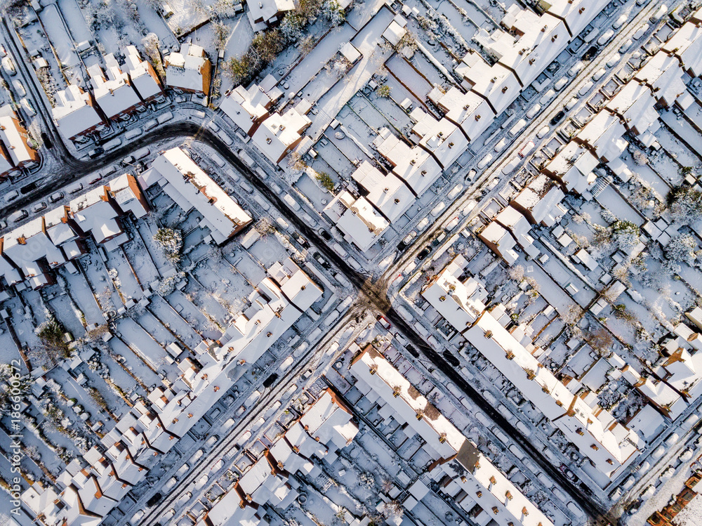 Aerial view of snow covered traditional housing suburbs in England. Snow, ice and adverse weather conditions bring things to a stand still in the housing estates of a British suburb