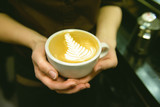 Cup of coffee. Latte art made by barista focus in milk and coffee. Vintage color