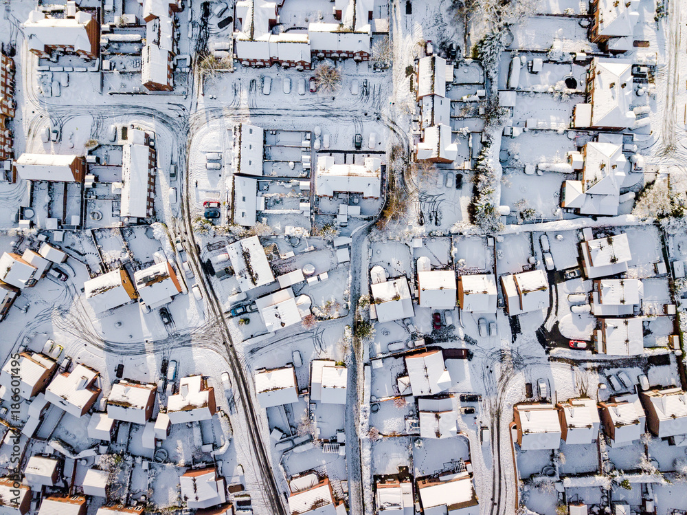 Aerial view of snow covered traditional housing suburbs in England. Snow, ice and adverse weather conditions bring things to a stand still in the housing estates of a British suburb