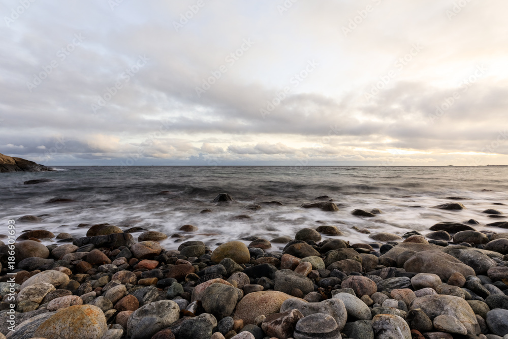 Pebble shore at Hove, Tromoy in Arendal, Norway. Raet National Park. Long exposure.