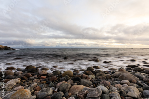 Pebble shore at Hove, Tromoy in Arendal, Norway. Raet National Park. Long exposure.
