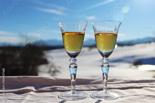 Close up  Brandy in Vintage-Gl  sern auf dem Balkon  traumhafte Winterlandschaft im Hintergrund