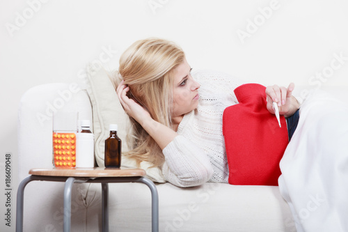 Woman being sick having flu lying on sofa