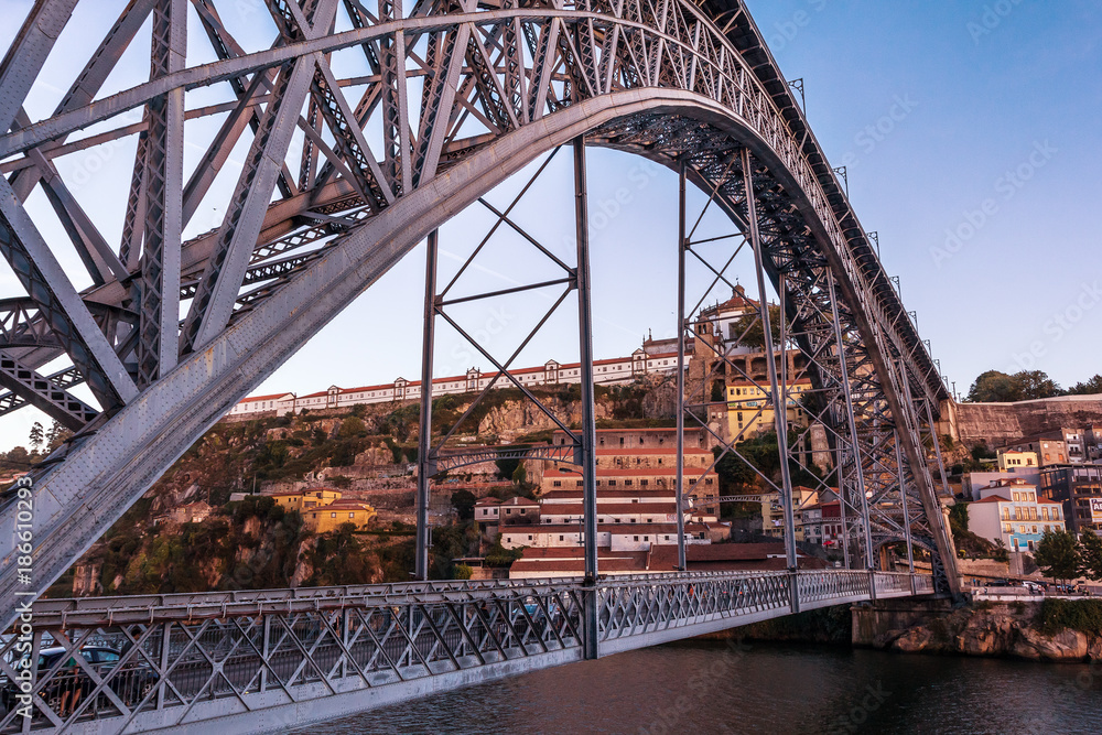 Perspective of the Dom Luís I bridge in Porto, Portugal, with Serra do Pilar in background.