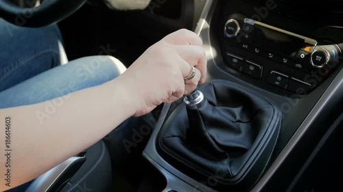 Slow motion closeup video of young woman shifting car manual gearbox