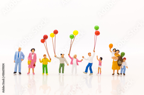 Miniature people: Childrens play balloon together wiht fun, using as background International day of families concept.