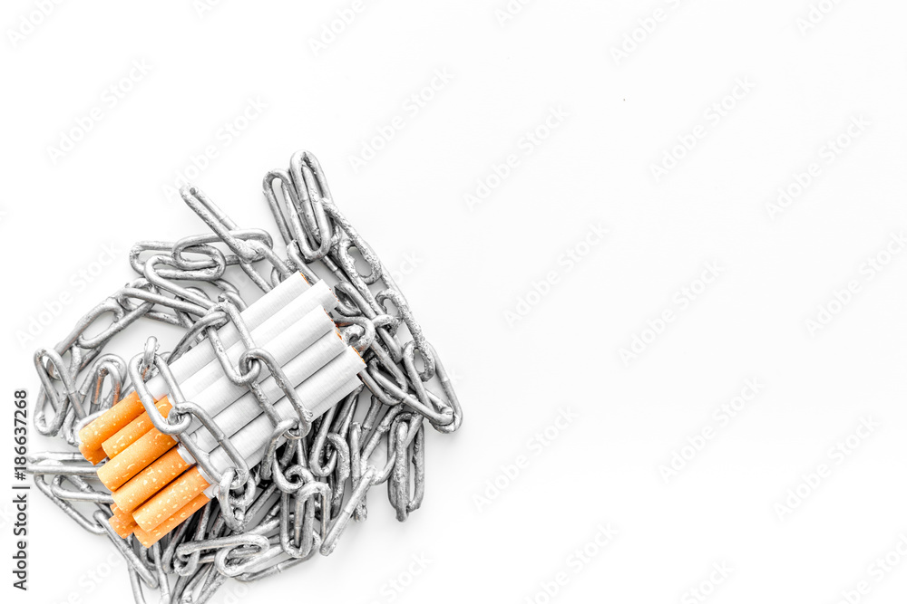 Quit smoking. Cigarettes in chains on white background top view copyspace Quit smoking. Cigarettes in chains on white background top view copyspace