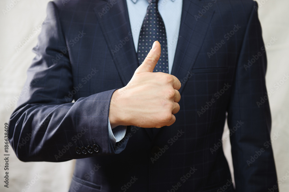 A man in a blue suit shows a gesture with his thumb A man in a blue suit shows a gesture with his thumb