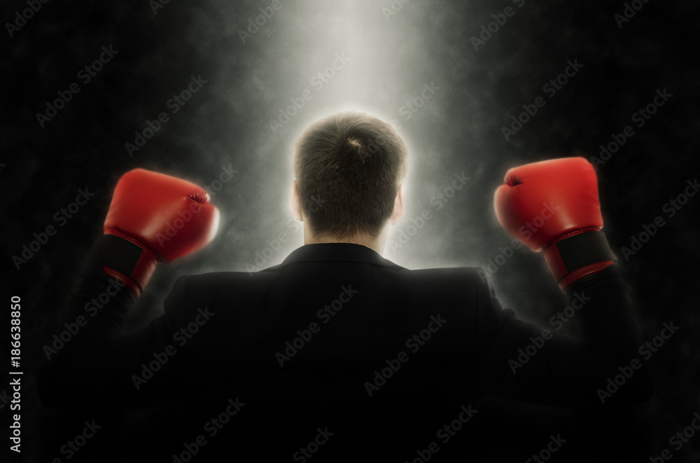 Businessman in boxing gloves on black