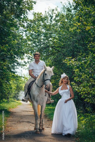 Man, bride and white horse in the park © keleny
