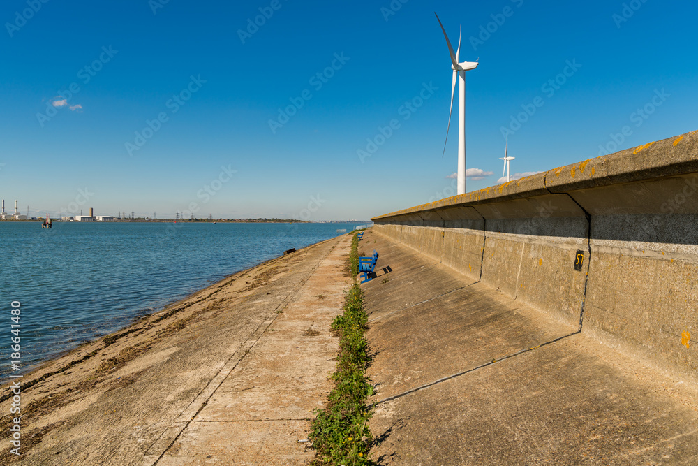 A bench and wind turbines in Queenborough, Isle of Sheppey, Kent, England, UK