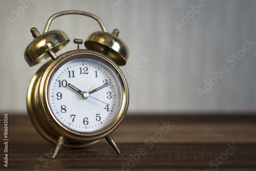 golden time clock - Golden bell clock on a wooden table background