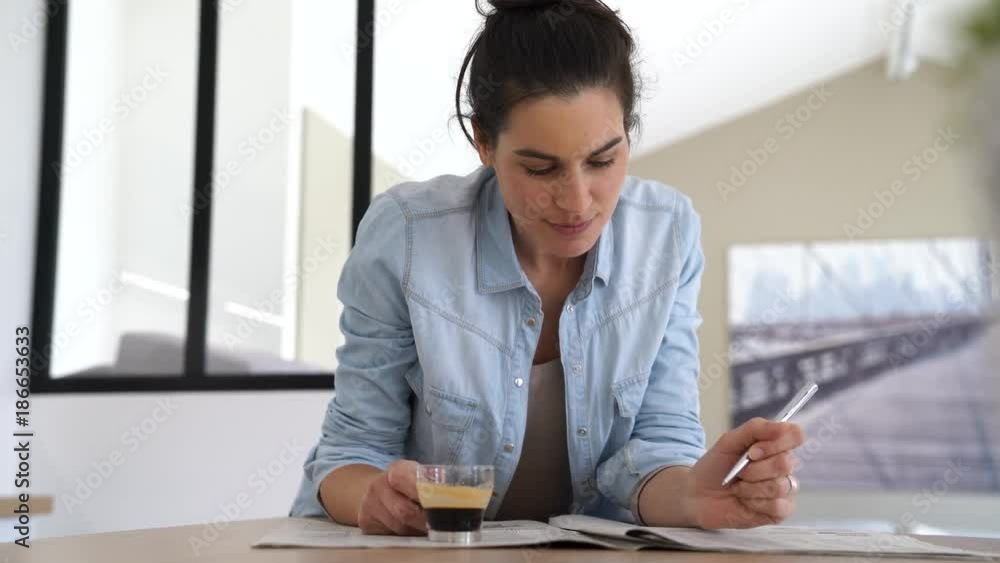 Brunette girl at home reading newspaper Brunette girl at home reading newspaper