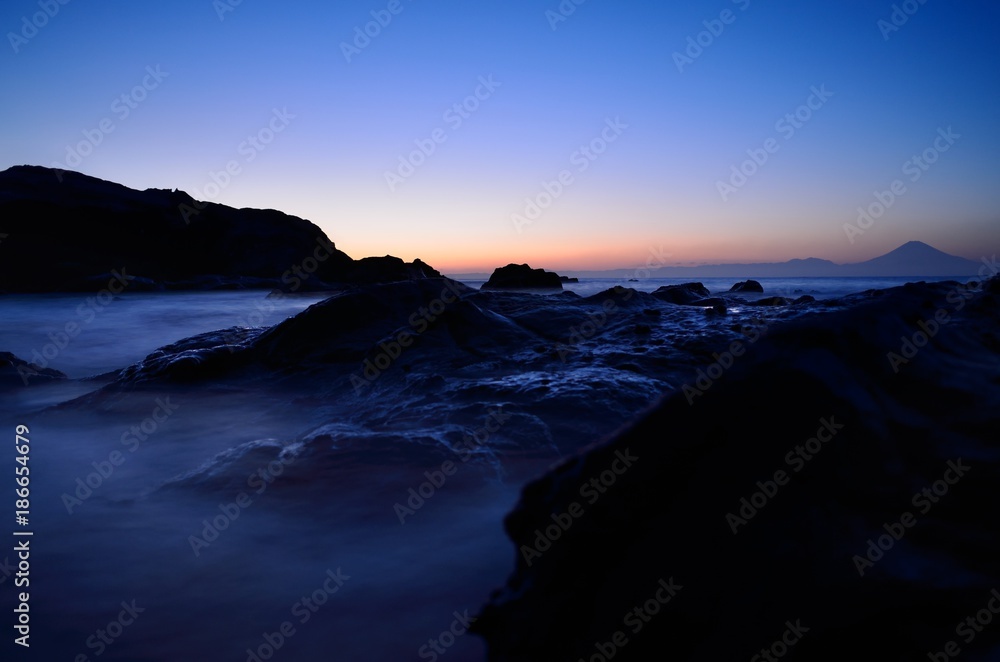 Mt. Fuji silhouette with reef at sunset slow shutter