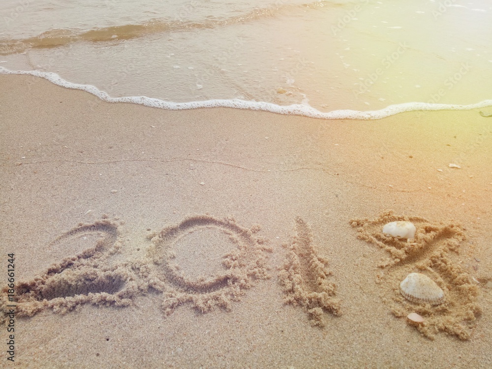 Happy New year 2018 with the waves beat at the beach and shell fragments. Happy New year 2018 with the waves beat at the beach and shell fragments.