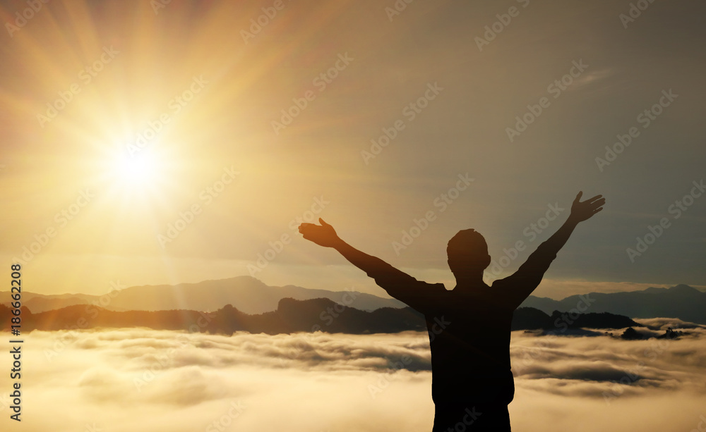 Man raised his arms in the mountains Fog and sunlight