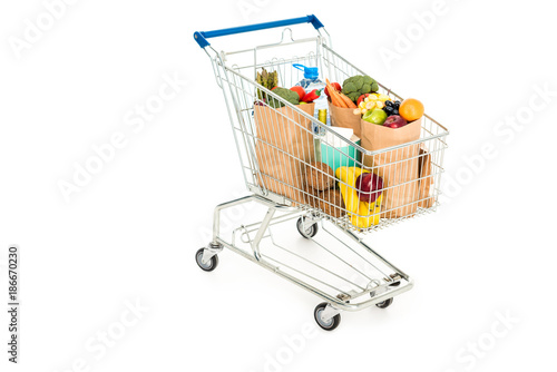 grocery bags in shopping trolley isolated on white