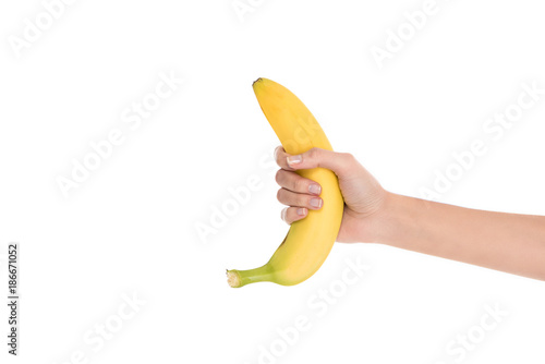 cropped shot of woman holding fresh banana in hand isolated on white