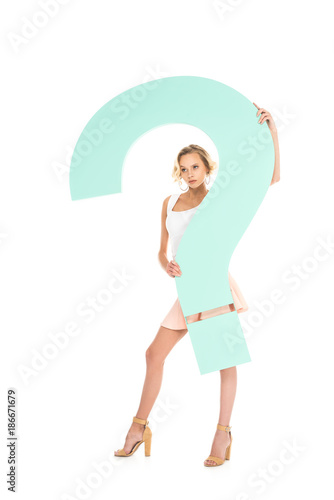 young woman with big question mark in hands looking at camera isolated on white