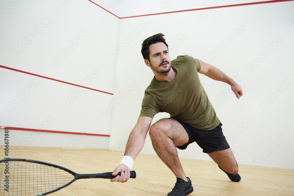 Man during squash match on court. Man during squash match on court.