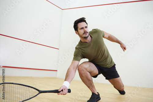 Man during squash match on court. © gpointstudio