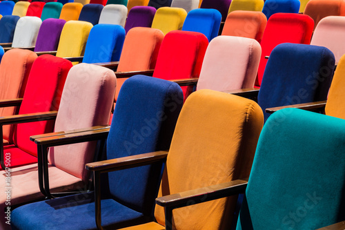 The auditorium in the theater. Multicolored spectator chairs.