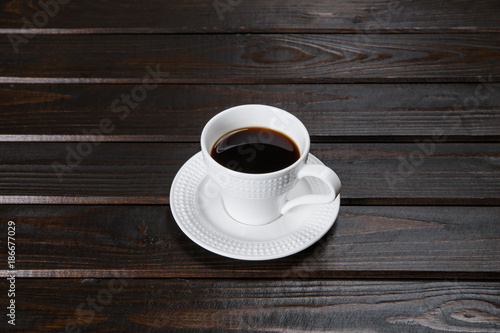 Mug of coffee on brown wooden background.