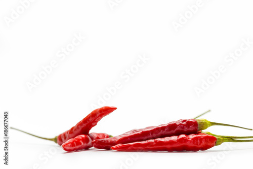 Red chilli peppers are laid on white background.