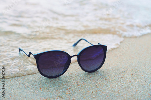 unglasses on the beach with beautiful blue sea in background
