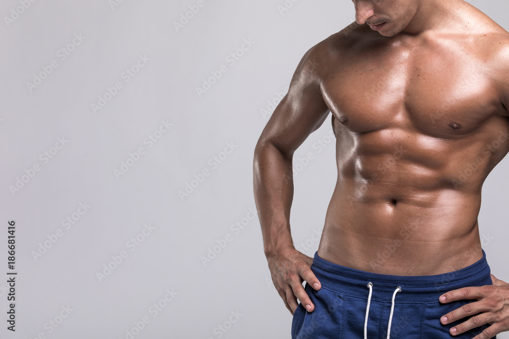 Tanned man with muscuar torso on grey backgrond Tanned man with muscuar torso on grey backgrond