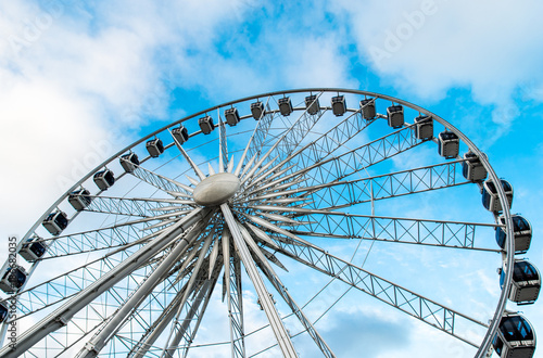Gdansk, Poland - August 10, 2017: Big ferris wheel in the old town of Gdansk, blu sky background. Center or old town in Gdansk, European polish culture city near baltic sea. Summer travel in Poland. © Yuliia