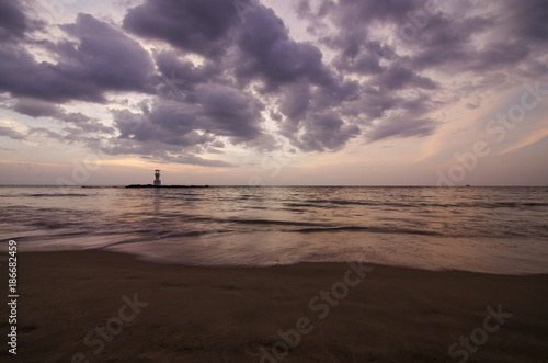 sunset on the beach and light house photo