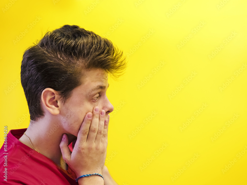 Portrait of a man surprised. Attractive hipster guy in a casual t-shirt looks with big eyes .. Concept of facial expression. Portrait of a man surprised. Attractive hipster guy in a casual t-shirt looks with big eyes .. Concept of facial expression.