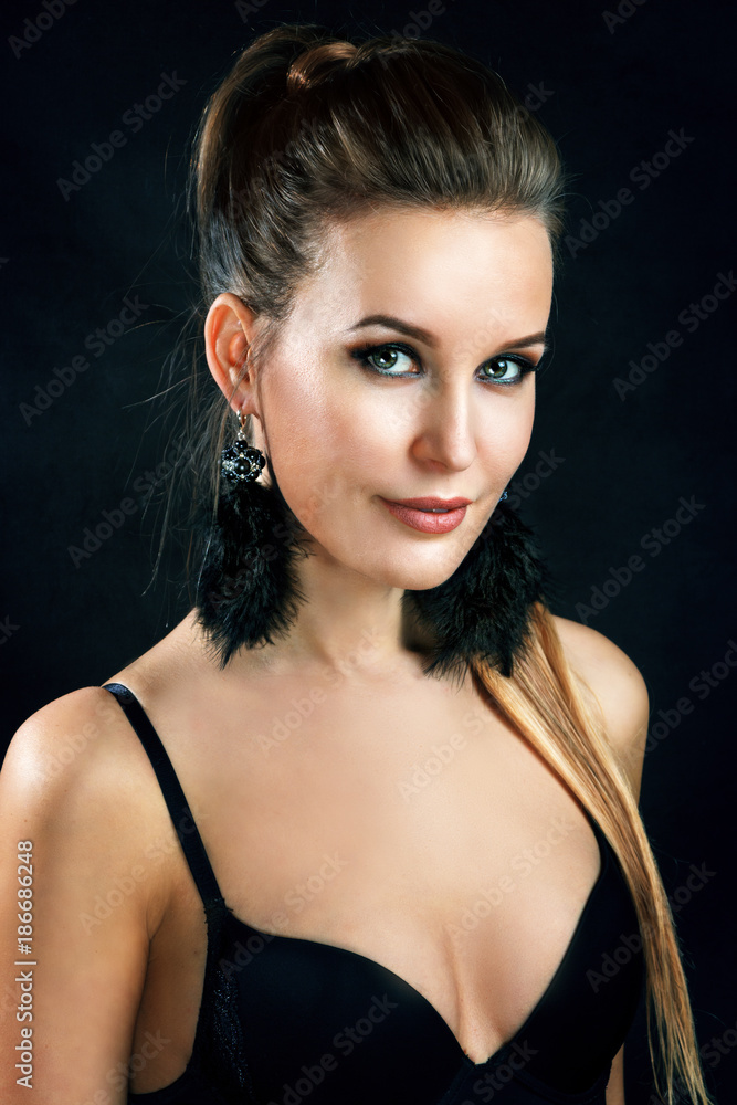 Beautiful blonde girl on a dark background in the studio Beautiful blonde girl on a dark background in the studio