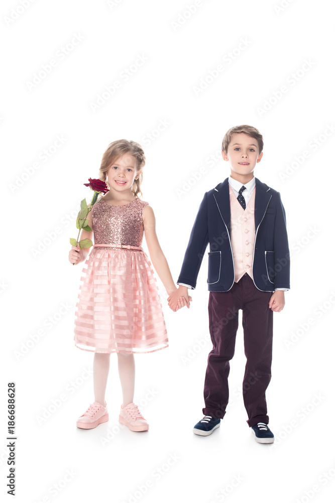 beautiful little kids holding hands and smiling at camera while girl holding rose flower isolated on white beautiful little kids holding hands and smiling at camera while girl holding rose flower isolated on white