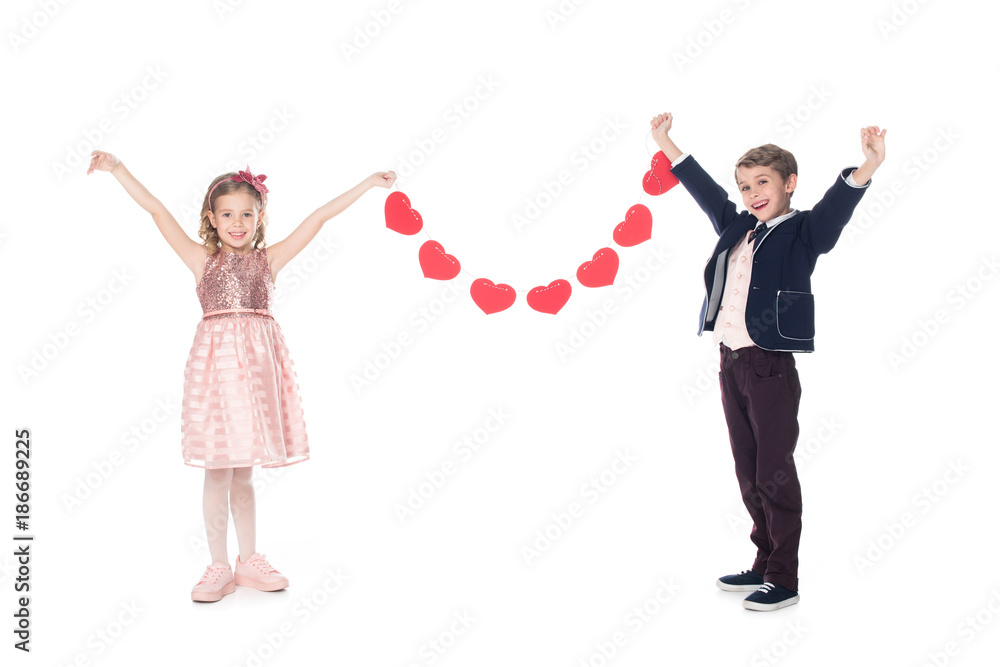 happy stylish children holding red hearts and smiling at camera isolated on white happy stylish children holding red hearts and smiling at camera isolated on white