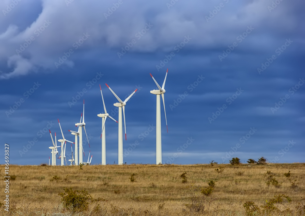 Wind turbine farm under the blue cloudy sky Wind turbine farm under the blue cloudy sky