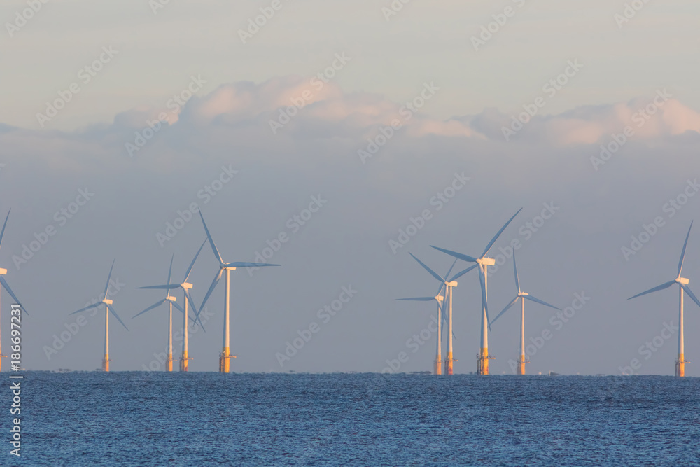 Offshore wind farm. Clean alternative energy turbines on the sea horizon.