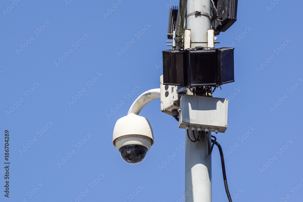 High tech overhead security camera with a blue sky