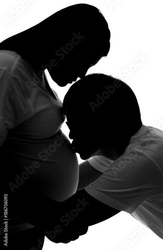 The silhouette of husband kiss his pregnant wife isolated on white
