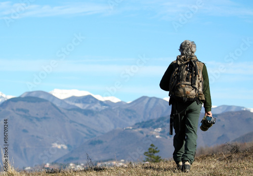 Trekker man walking alone though mountain  photo