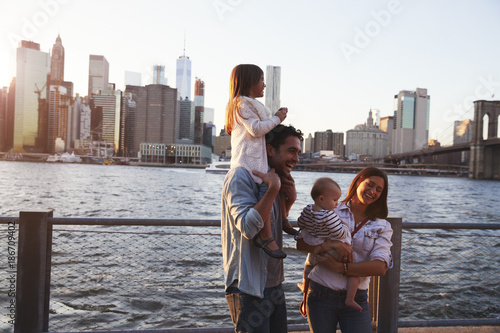 Young family with daughters standing on quayside, side view © Monkey Business