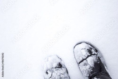 Legs in boots standing on a snow white field