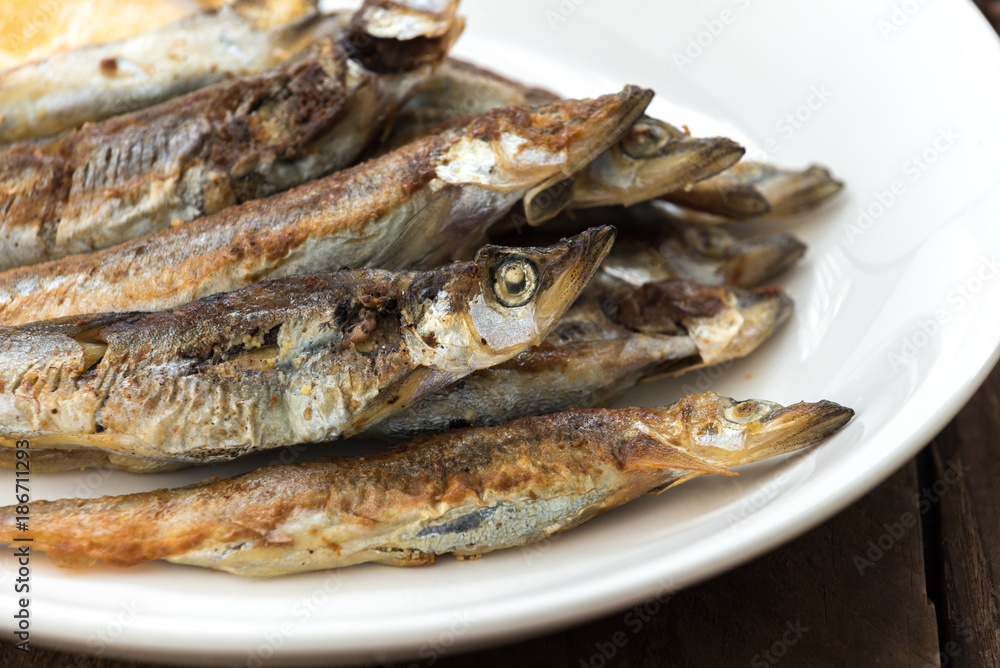 Grilled fish capelin or shishamo on white plate Grilled fish capelin or shishamo on white plate
