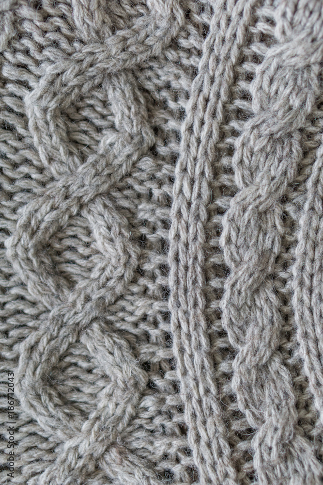 Closeup. Wool knitted fabric. Wool textiles. Colorful Wool scarv. Background. Large binding needles. Closeup. Wool knitted fabric. Wool textiles. Colorful Wool scarv. Background. Large binding needles.