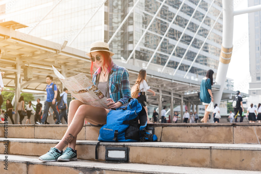 Woman westerner looking at map during city tour in the morning, planning for today's trip Woman westerner looking at map during city tour in the morning, planning for today's trip