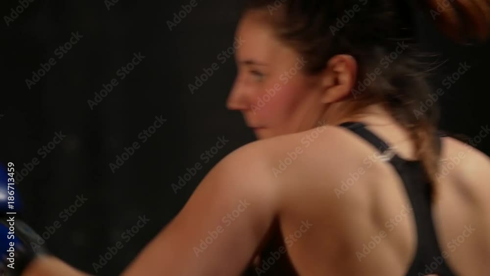 Strong woman fighter mma in boxing gloves hitting on punching bag Strong woman fighter mma in boxing gloves hitting on punching bag